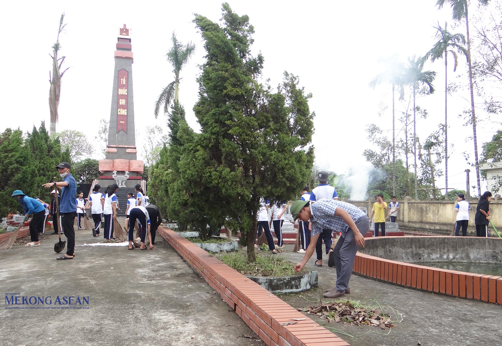 Lãnh đạo UBND xã Thanh Xuân (huyện Thanh Hà) cùng các cán bộ địa phương, giáo viên và các em học sinh thực hiện quét dọn, chặt tỉa cây cối nghiêng ngả sau bão tại Nghĩa trang Liệt sĩ xã. Ảnh chụp chiều 25/9.