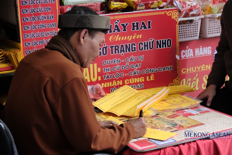 Những bài văn khấn, lá sớ viết sẵn được bày bán với mức giá 30.000-50.000 đồng. Người dâng lễ sẽ điền tên, tuổi, địa chỉ và những điều mong cầu, đặt vào mâm lễ. Ảnh: