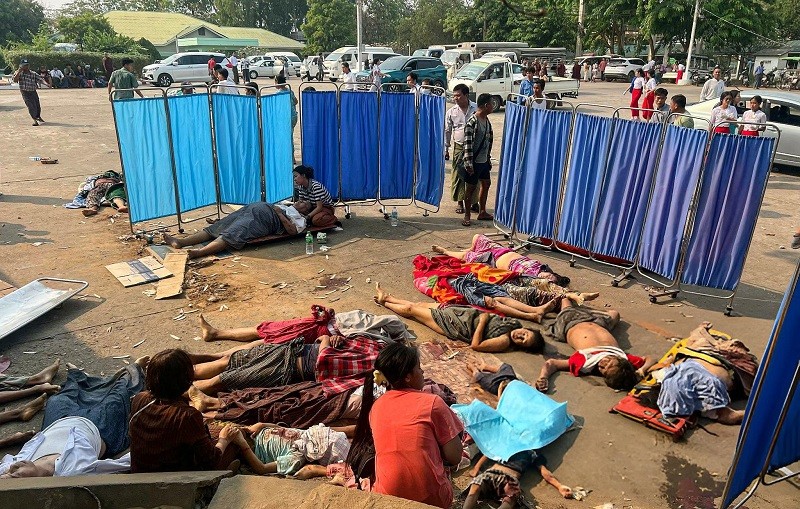 Nhiều bệnh nhân không có giường, phải nằm đất do bệnh viện quá tải. Ảnh: AFP