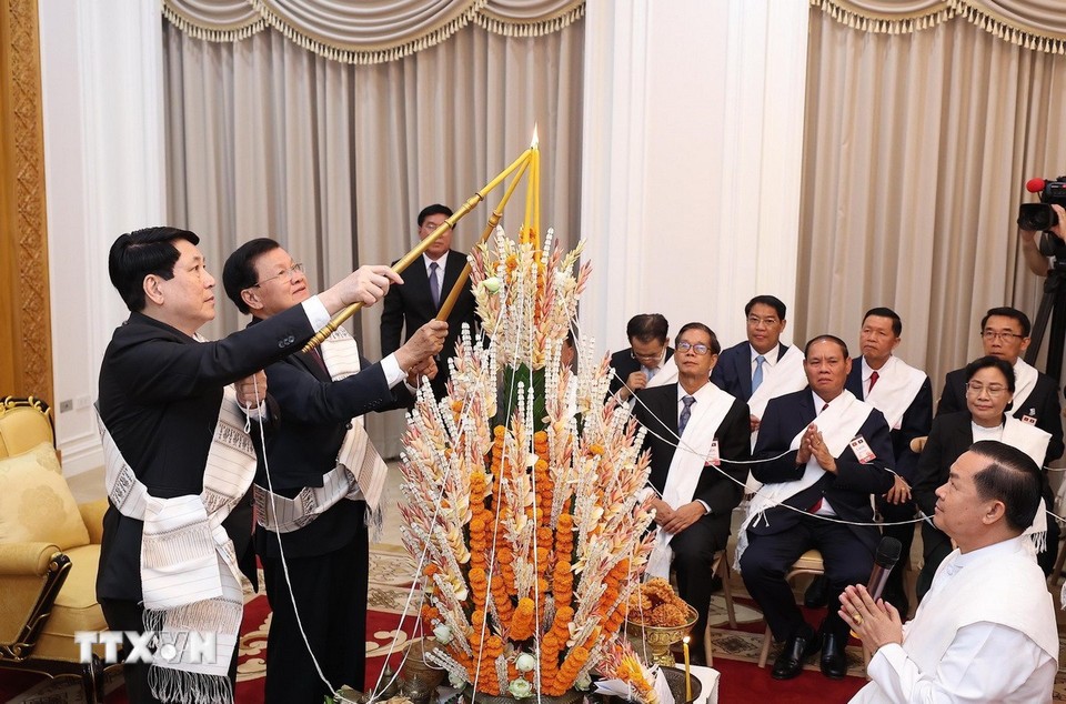 Chủ tịch nước Lương Cường cùng Tổng Bí thư, Chủ tịch nước Lào Thongloun Sisoulith dự lễ buộc chỉ cầu bình an, may mắn nhân dịp Tết Bounpimay của Lào. Ảnh: TTXVN.