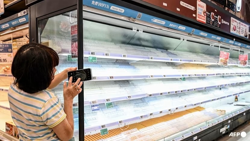 Kệ hàng trống trơn khi người dân đổ xô mua nhu yếu phẩm tại một siêu thị ở Thâm Quyến. Ảnh: AFP