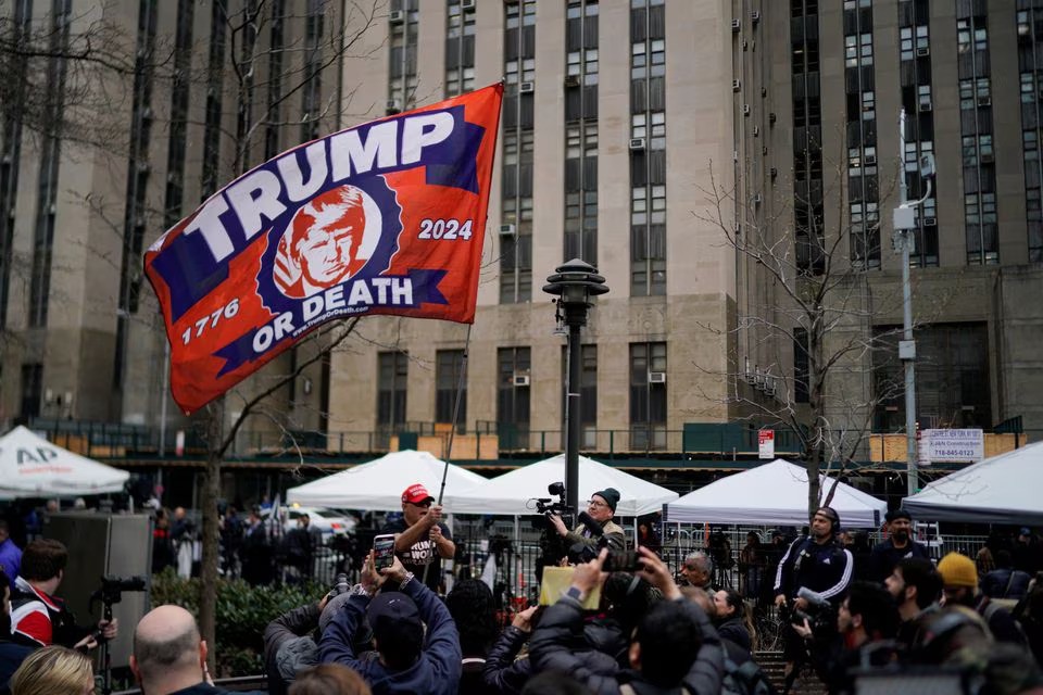Người biểu t&igrave;nh ủng hộ &ocirc;ng Trump vẫy cờ b&ecirc;n ngo&agrave;i T&ograve;a &aacute;n H&igrave;nh sự Manhattan. Ảnh: Reuters