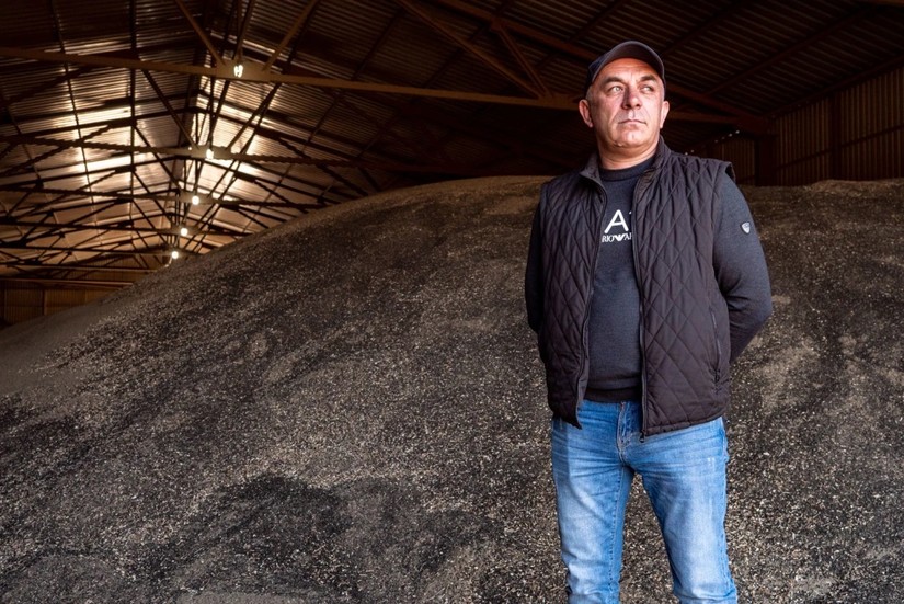&Ocirc;ng Roman Tarasevich, người n&ocirc;ng d&acirc;n Ukraine đứng b&ecirc;n một n&uacute;i hạt hướng dương chưa b&aacute;n được trong một nh&agrave; kho ở Zaporizhzhia. Ảnh: NBC