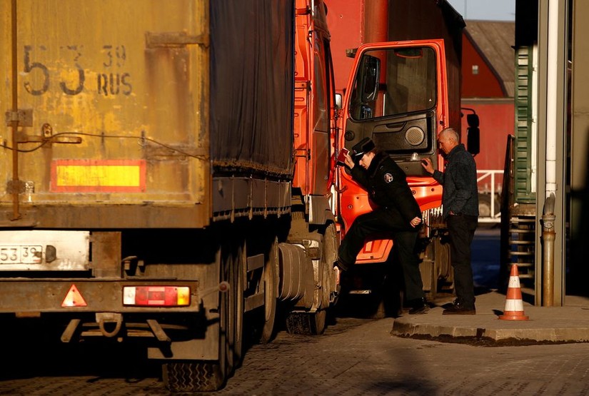 Một người l&iacute;nh bi&ecirc;n ph&ograve;ng kiểm tra chiếc xe tải tại khu vực Kybartai - bi&ecirc;n giới giữa Nga v&agrave; Lithuania. Ảnh: Reuters