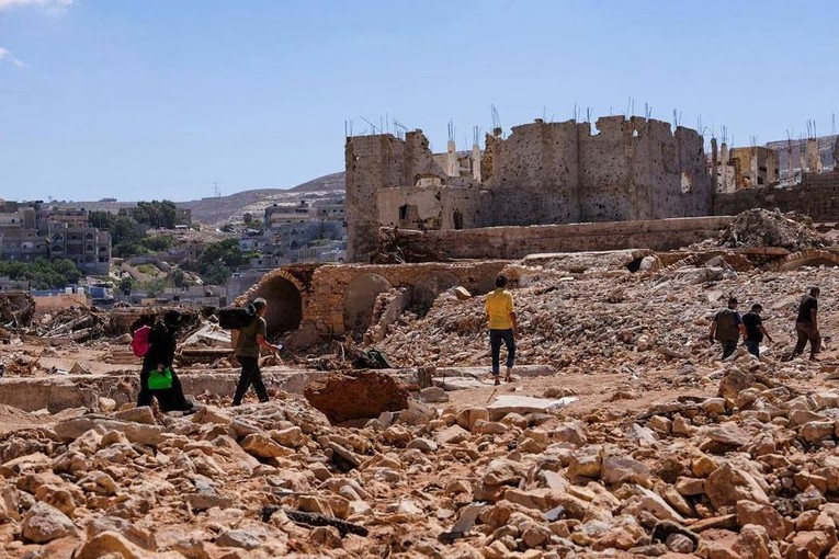 Người d&acirc;n Derna, Libya t&igrave;m kiếm trong c&aacute;c đống đổ n&aacute;t. Ảnh: Reuters