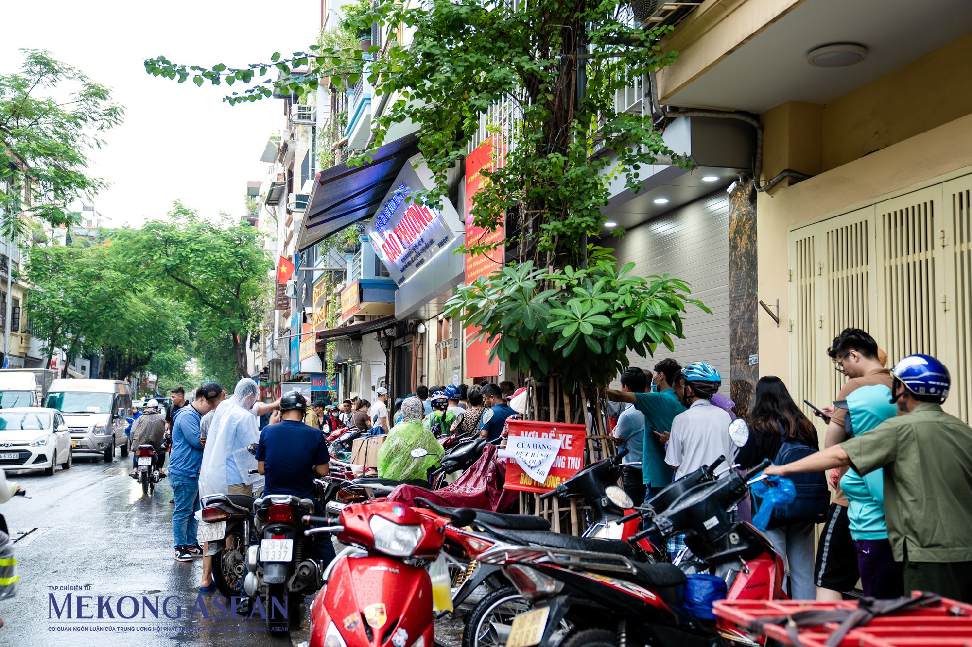 Bất chấp những cơn mưa nặng hạt, d&ograve;ng người xếp h&agrave;ng vẫn ki&ecirc;n nhẫn mặc &aacute;o mưa chờ tới lượt để mua bằng được những chiếc b&aacute;nh trung thu truyền thống.