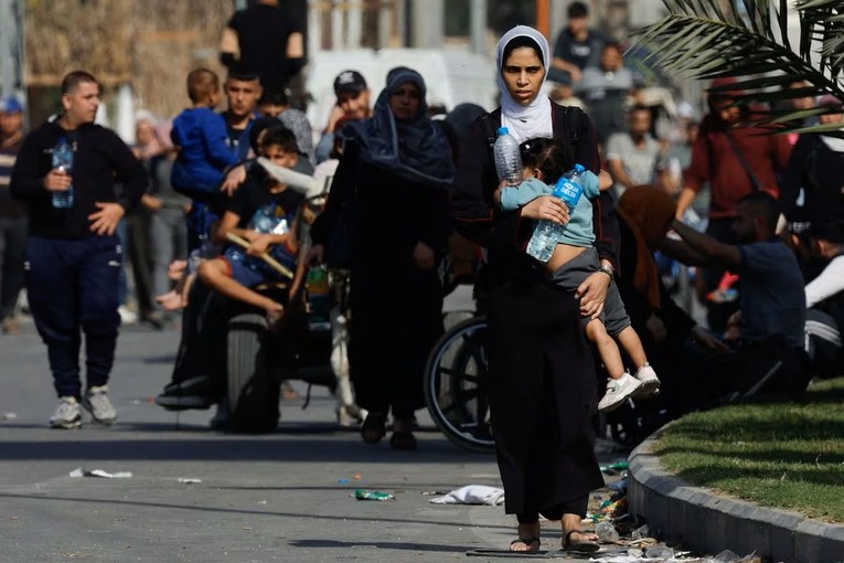 Một người phụ nữ Palestine bế đứa b&eacute; tại trung t&acirc;m Dải Gaza, ng&agrave;y 9/11. Ảnh: Reuters